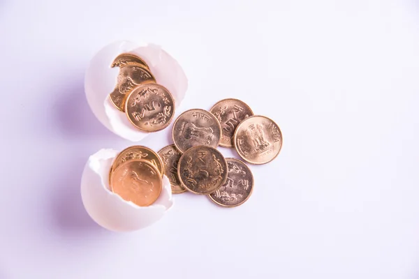 Monedas indias de cinco rupias que emergen de huevo agrietado, rupias indias y huevo agrietado, enfoque selectivo, aislado sobre fondo blanco —  Fotos de Stock