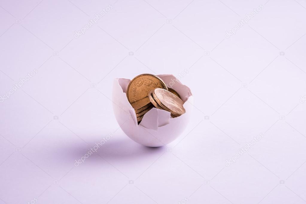 indian five rupee coins emerging from cracked egg, indian rupees and cracked egg, selective focus, isolated over white background