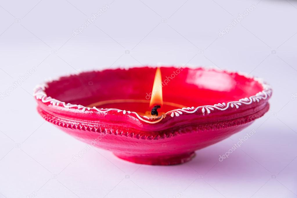 single Clay diya lamp lit during diwali festival. happy diwali Greetings Card Design, Indian Hindu Festival of lights called Diwali