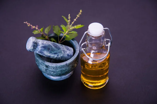 Tulsi olie of Heilige basilicumolie met mortier en stamper, tulsi of Heilige basilicum is een koningin van kruid sinds de oudheid in India in de Ayurveda — Stockfoto