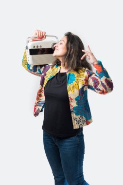 Hintli Asyalı kız ya da genç kadın kulaklıkla radyo dinliyor, ritimli dans ediyor ve eğleniyor.