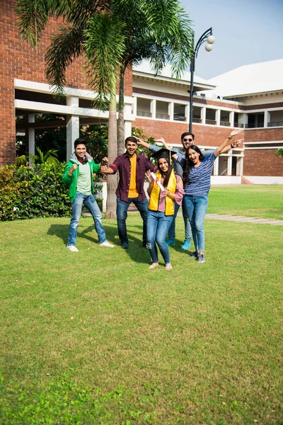 Ασιάτες Ινδοί Φοιτητές Λαμβάνουν Πτυχίο Ενώ Φίλοι Γιορτάζουν Στην Πανεπιστημιούπολη — Φωτογραφία Αρχείου
