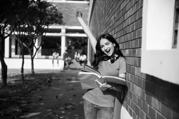 亚裔印度大学生的工作重点是笔记本电脑或看书 而其他同学的背景是大学校园里的户外图片 — 图库照片