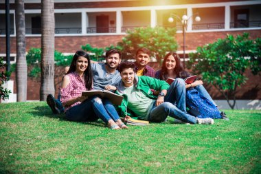Kolej öğrencilerinden oluşan neşeli Hintli genç bir grup ya da arkadaşlar kampüste otururken, ayakta ya da yürürken birlikte gülüyorlar.