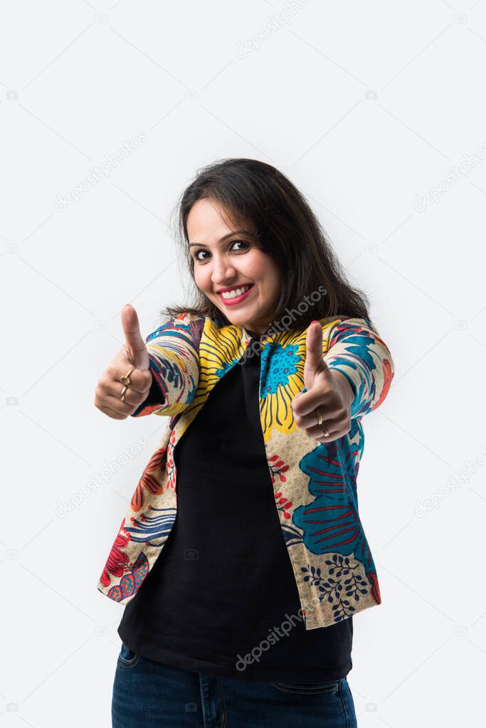 Portrait of pretty Asian Indian young girl presenting empty space or with hands crossed