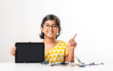 Elektronik deney - Asyalı Hintli küçük kız öğrenci kablolarla, bağlantılarla, dizüstü bilgisayarla veya tablet bilgisayarla bilim yapıyor veya okuyor