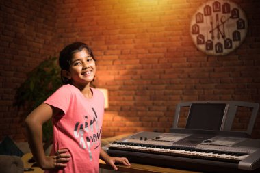 Asyalı Hintli çocuk evde bilgisayar ya da tablet kullanarak müzik ya da müzik aleti öğreniyor, hobiyi ikna ediyor