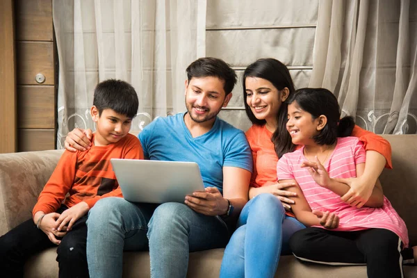 Familia India Sentada Sofá Usando Smartphone Laptop Tablet Viendo Películas —  Fotos de Stock