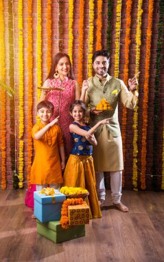 Diwali veya Rakshabandhan Kutlaması - Dört kişilik Hint ailesi Deepavali veya Bhai Dooj festivalini tatlı laddoo, yağ lambası ve şeker ve şeker kutuları ile kutluyor, yemek yiyor veya selfie çekiyor