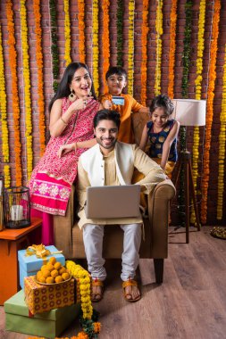 Hint ailesi online alışveriş için dizüstü bilgisayar kullanıyor ve Diwali festivalindeki kredi kartını kullanıyor.