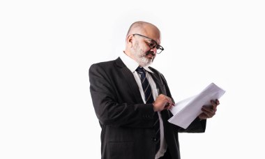 Beyaz arka planda dururken elinde kağıt tutarak ya da okuyarak Hintli kıdemli işadamının portresi