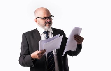 Beyaz arka planda dururken elinde kağıt tutarak ya da okuyarak Hintli kıdemli işadamının portresi