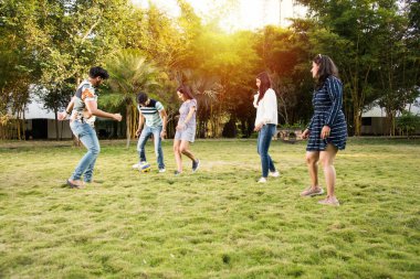 Hintli genç arkadaşlar parkta futbol ya da futbol oynuyorlar ve eğleniyorlar.