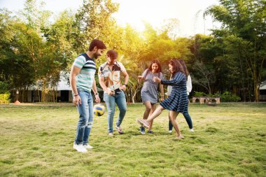 Hintli genç arkadaşlar parkta futbol ya da futbol oynuyorlar ve eğleniyorlar.