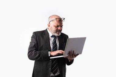 Üst düzey Hintli iş adamının portresi dizüstü bilgisayar, tablet ya da akıllı telefon kullanarak beyaz arkaplana karşı durarak,