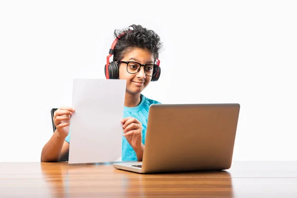 Indian male syudent or kid studying online using laptop. Asian child attending online school using computer