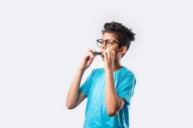 Hint Asyalı küçük çocuk mızıka ya da ağız organı çalıyor, erken öğrenme kavramı.