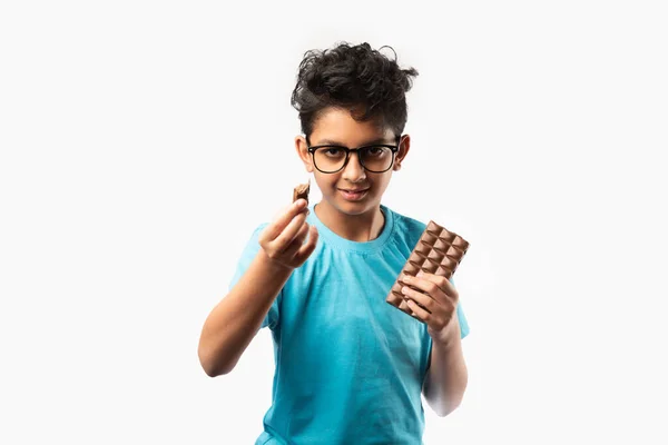 Intialainen Aasialainen Onnellinen Poika Syö Suklaalevyä Seisoo Eristyksissä Valkoista Taustaa — kuvapankkivalokuva