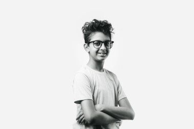 Gözlüklü neşeli Hintli küçük çocuğun portresi başarıyı kutluyor, beyaz arka planda duruyor.