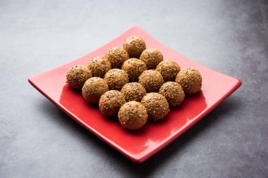 Susam tohumu jaggery topu ya da ke laddo ve tilgul ya da gul laddu Hindistan 'daki Makar Sankranti Festivali için kasede servis yaparlar.