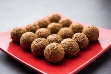 Susam tohumu jaggery topu ya da ke laddo ve tilgul ya da gul laddu Hindistan 'daki Makar Sankranti Festivali için kasede servis yaparlar.