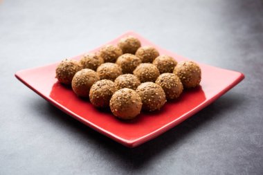 Susam tohumu jaggery topu ya da ke laddo ve tilgul ya da gul laddu Hindistan 'daki Makar Sankranti Festivali için kasede servis yaparlar.