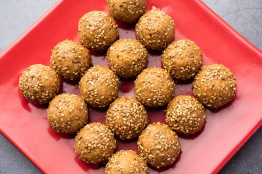 Susam tohumu jaggery topu ya da ke laddo ve tilgul ya da gul laddu Hindistan 'daki Makar Sankranti Festivali için kasede servis yaparlar.