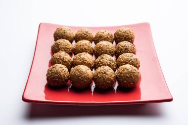 Susam tohumu jaggery topu ya da ke laddo ve tilgul ya da gul laddu Hindistan 'daki Makar Sankranti Festivali için kasede servis yaparlar.