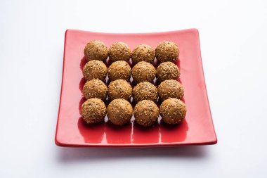 Susam tohumu jaggery topu ya da ke laddo ve tilgul ya da gul laddu Hindistan 'daki Makar Sankranti Festivali için kasede servis yaparlar.