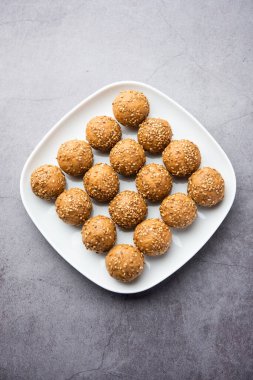 Susam tohumu jaggery topu ya da ke laddo ve tilgul ya da gul laddu Hindistan 'daki Makar Sankranti Festivali için kasede servis yaparlar.