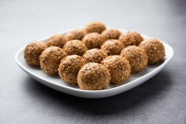 Susam tohumu jaggery topu ya da ke laddo ve tilgul ya da gul laddu Hindistan 'daki Makar Sankranti Festivali için kasede servis yaparlar.