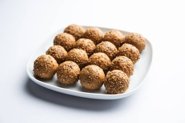 Susam tohumu jaggery topu ya da ke laddo ve tilgul ya da gul laddu Hindistan 'daki Makar Sankranti Festivali için kasede servis yaparlar.