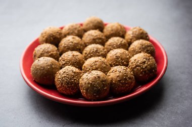 Susam tohumu jaggery topu ya da ke laddo ve tilgul ya da gul laddu Hindistan 'daki Makar Sankranti Festivali için kasede servis yaparlar.