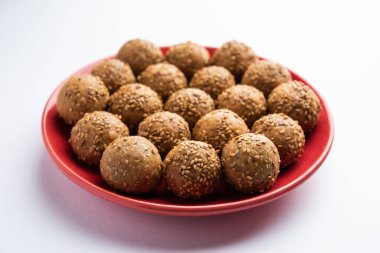Susam tohumu jaggery topu ya da ke laddo ve tilgul ya da gul laddu Hindistan 'daki Makar Sankranti Festivali için kasede servis yaparlar.