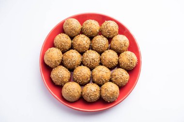 Susam tohumu jaggery topu ya da ke laddo ve tilgul ya da gul laddu Hindistan 'daki Makar Sankranti Festivali için kasede servis yaparlar.