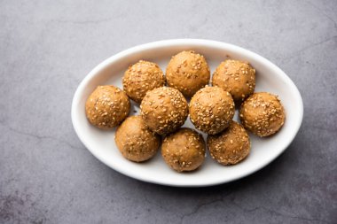 Susam tohumu jaggery topu ya da ke laddo ve tilgul ya da gul laddu Hindistan 'daki Makar Sankranti Festivali için kasede servis yaparlar.