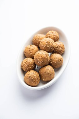 Susam tohumu jaggery topu ya da ke laddo ve tilgul ya da gul laddu Hindistan 'daki Makar Sankranti Festivali için kasede servis yaparlar.