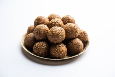 Susam tohumu jaggery topu ya da ke laddo ve tilgul ya da gul laddu Hindistan 'daki Makar Sankranti Festivali için kasede servis yaparlar.