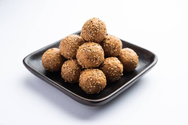 Susam tohumu jaggery topu ya da ke laddo ve tilgul ya da gul laddu Hindistan 'daki Makar Sankranti Festivali için kasede servis yaparlar.