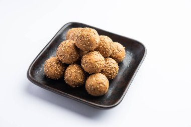 Susam tohumu jaggery topu ya da ke laddo ve tilgul ya da gul laddu Hindistan 'daki Makar Sankranti Festivali için kasede servis yaparlar.