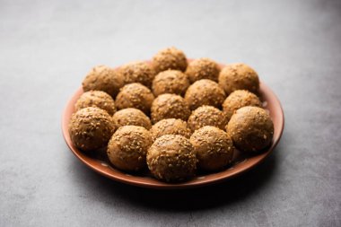 Susam tohumu jaggery topu ya da ke laddo ve tilgul ya da gul laddu Hindistan 'daki Makar Sankranti Festivali için kasede servis yaparlar.
