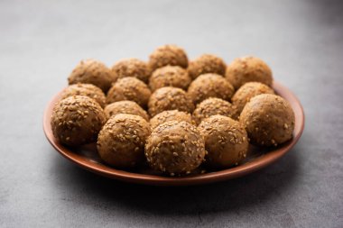 Susam tohumu jaggery topu ya da ke laddo ve tilgul ya da gul laddu Hindistan 'daki Makar Sankranti Festivali için kasede servis yaparlar.
