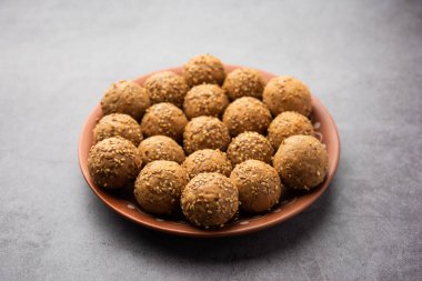 Susam tohumu jaggery topu ya da ke laddo ve tilgul ya da gul laddu Hindistan 'daki Makar Sankranti Festivali için kasede servis yaparlar.
