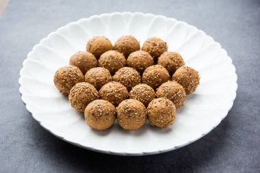 Susam tohumu jaggery topu ya da ke laddo ve tilgul ya da gul laddu Hindistan 'daki Makar Sankranti Festivali için kasede servis yaparlar.