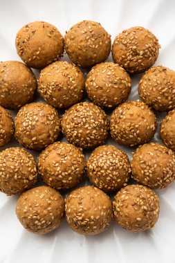 Susam tohumu jaggery topu ya da ke laddo ve tilgul ya da gul laddu Hindistan 'daki Makar Sankranti Festivali için kasede servis yaparlar.