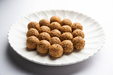 Susam tohumu jaggery topu ya da ke laddo ve tilgul ya da gul laddu Hindistan 'daki Makar Sankranti Festivali için kasede servis yaparlar.