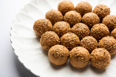 Susam tohumu jaggery topu ya da ke laddo ve tilgul ya da gul laddu Hindistan 'daki Makar Sankranti Festivali için kasede servis yaparlar.