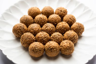 Susam tohumu jaggery topu ya da ke laddo ve tilgul ya da gul laddu Hindistan 'daki Makar Sankranti Festivali için kasede servis yaparlar.