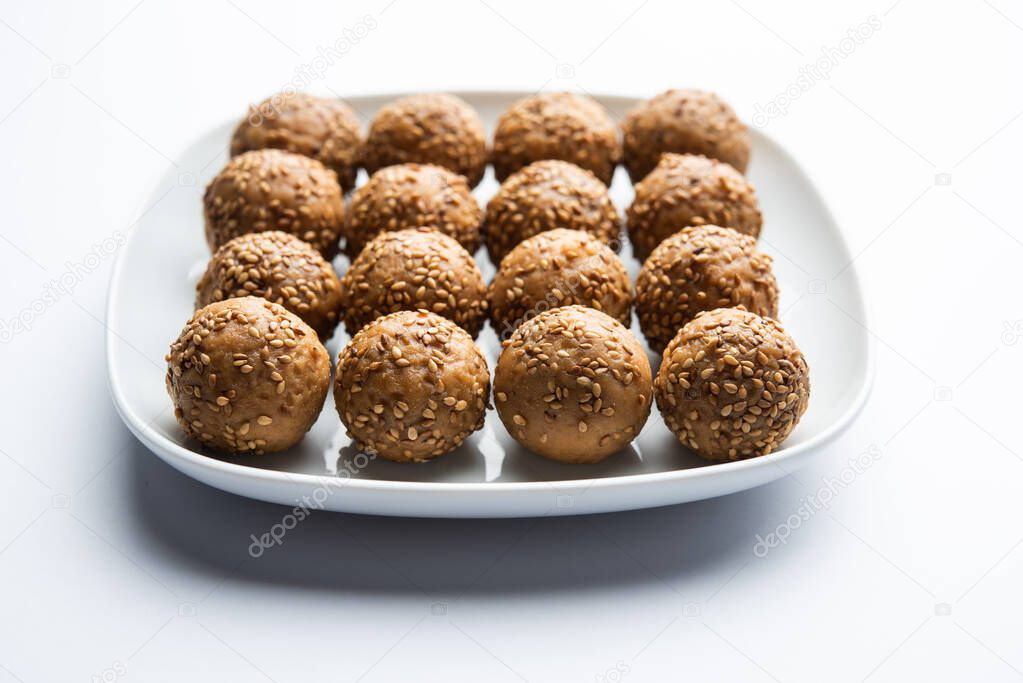 Sesame seed jaggery ball or til ke laddo and tilgul or til gul laddu served in bowl for Makar Sankranti Festival in India