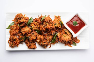 Havuçlu börek veya Gajar ke pakore veya pakode veya bajji veya bhaji, Hint aperatifi domates ketçaplı bir tabakta servis edilir.